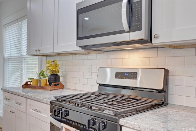 kitchen featuring decorative backsplash, white cabinetry, light stone counters, and stainless steel appliances