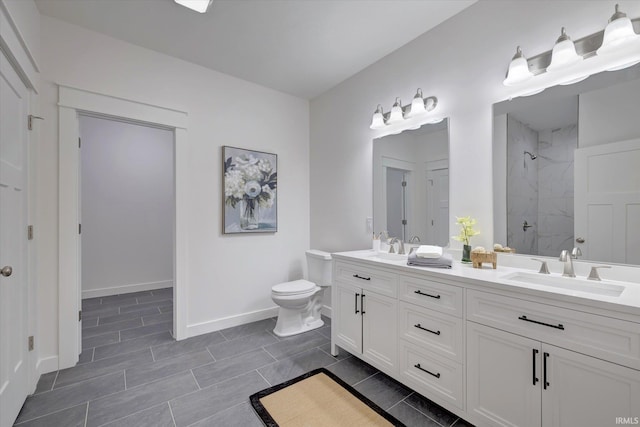 bathroom featuring vanity, a tile shower, and toilet