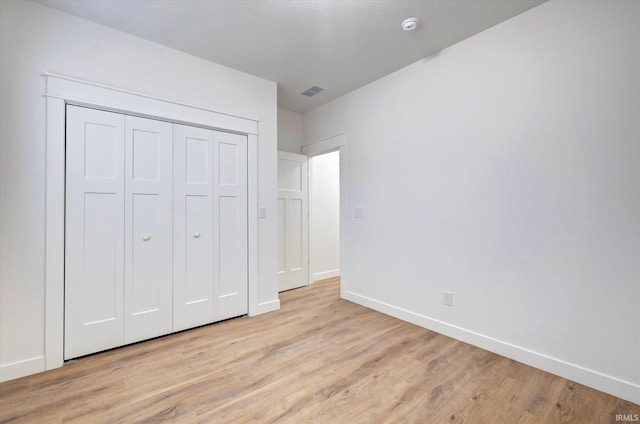 unfurnished bedroom featuring a closet and light hardwood / wood-style flooring