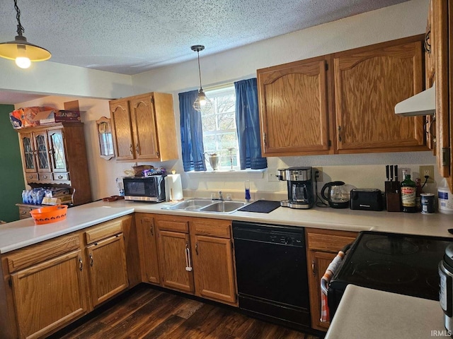 kitchen with hanging light fixtures, black appliances, dark hardwood / wood-style floors, and sink