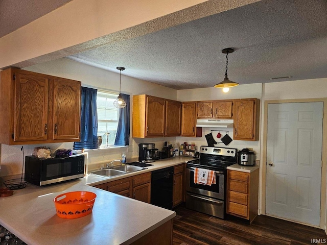 kitchen with hanging light fixtures, a textured ceiling, dark wood-type flooring, and appliances with stainless steel finishes