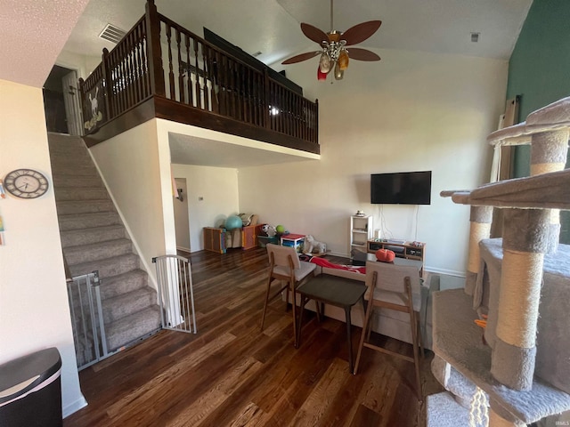 living room with ceiling fan, dark hardwood / wood-style floors, and high vaulted ceiling