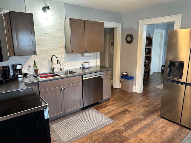 kitchen featuring decorative backsplash, dark wood-type flooring, sink, dark brown cabinetry, and appliances with stainless steel finishes