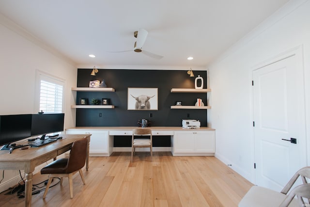 office area with built in desk, ceiling fan, ornamental molding, and light hardwood / wood-style flooring