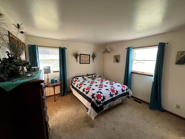 bedroom with multiple windows and carpet