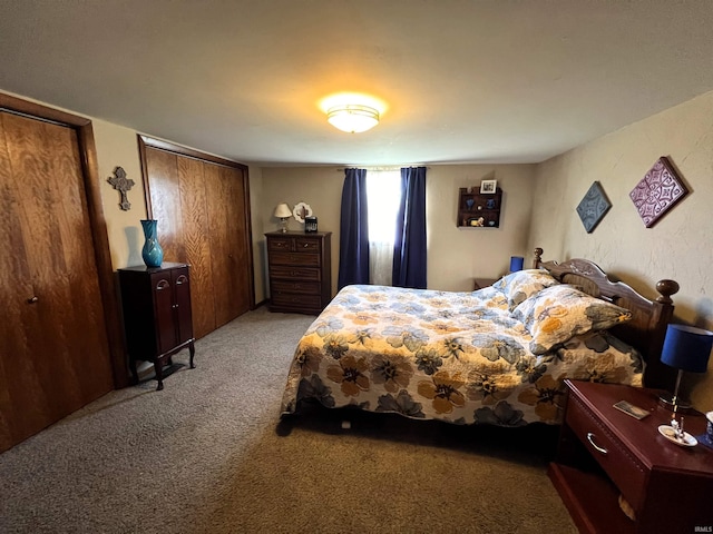 bedroom featuring two closets and light colored carpet