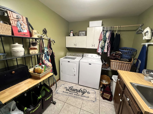 washroom featuring washer and dryer, cabinets, sink, and light tile patterned floors