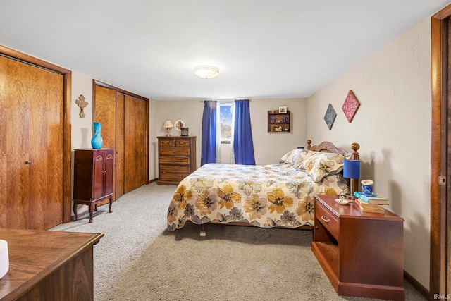 carpeted bedroom featuring two closets