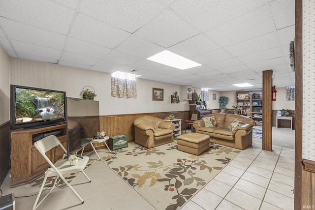 tiled living room with a paneled ceiling and wooden walls