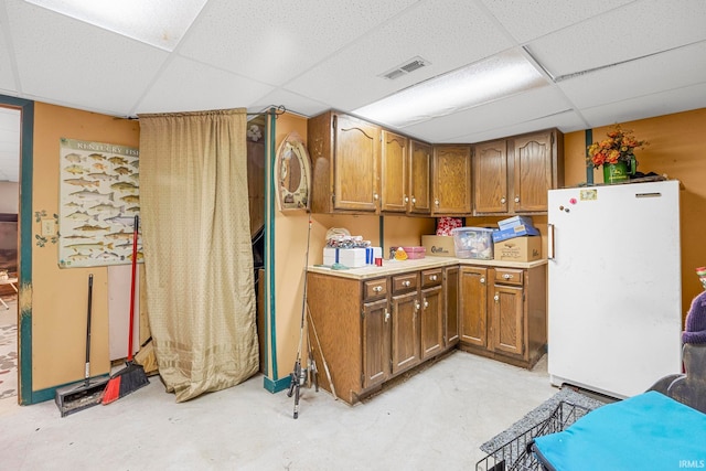 kitchen featuring a paneled ceiling and white fridge