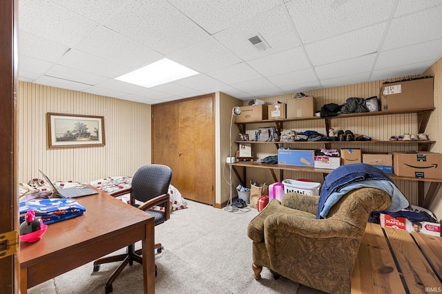 carpeted home office with a drop ceiling