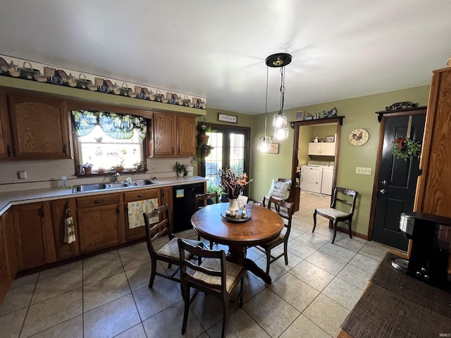 dining room featuring sink, light tile patterned floors, and independent washer and dryer