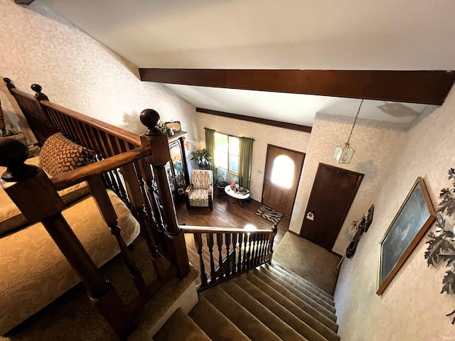 staircase with beamed ceiling and wood-type flooring