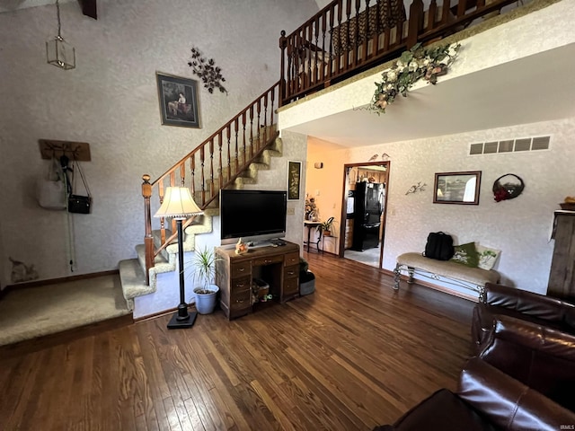 living room with a high ceiling and wood-type flooring