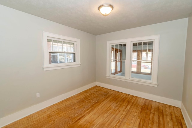 unfurnished room featuring hardwood / wood-style floors and a textured ceiling