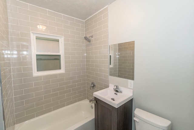 full bathroom featuring tiled shower / bath, vanity, a textured ceiling, and toilet