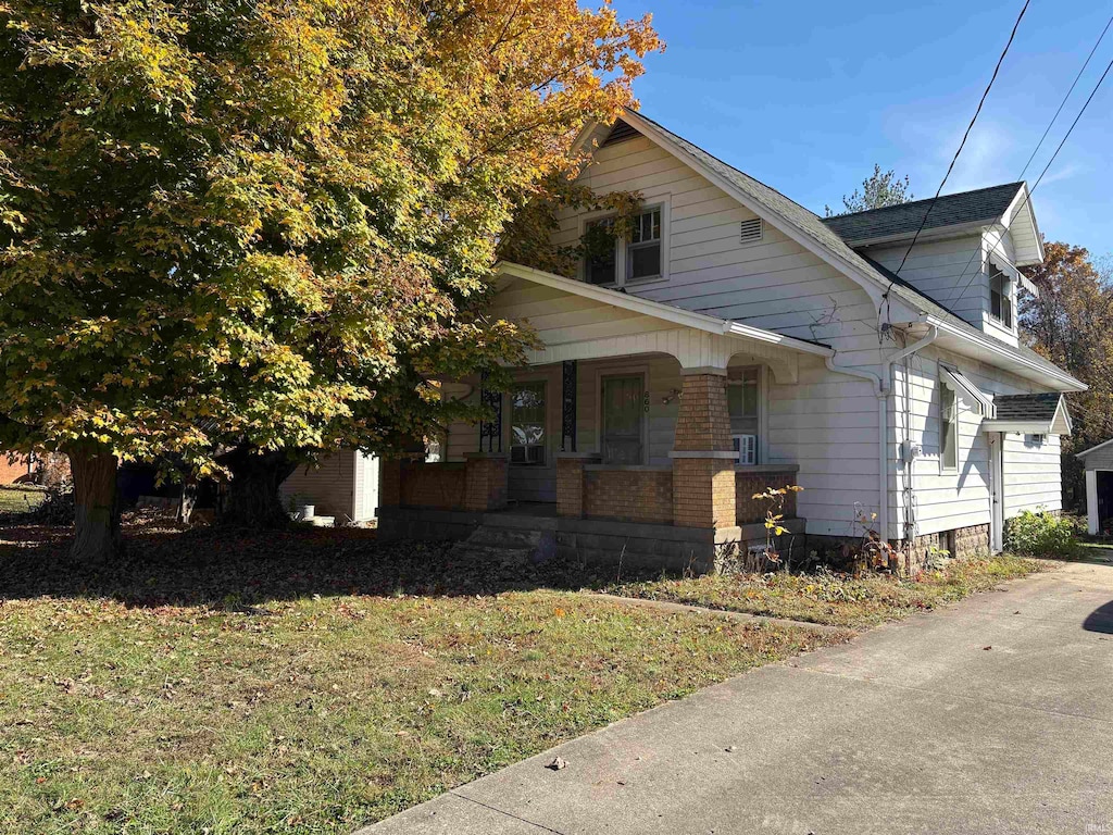 view of side of home with a lawn and covered porch