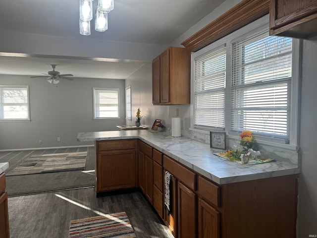 kitchen with ceiling fan, pendant lighting, dark hardwood / wood-style floors, and kitchen peninsula