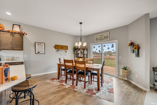 dining space with a chandelier and light wood-type flooring