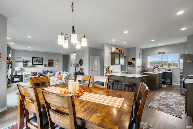 dining area with hardwood / wood-style flooring and a chandelier