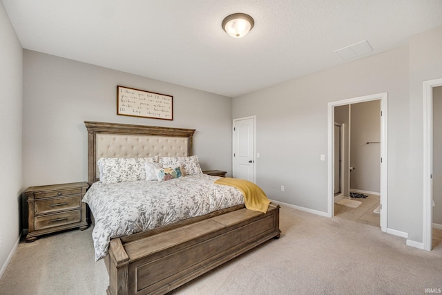 bedroom featuring light carpet and ensuite bath