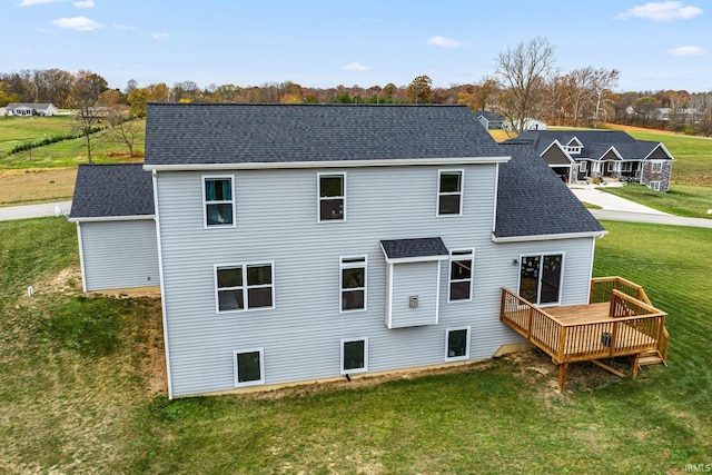 back of property with a yard and a wooden deck