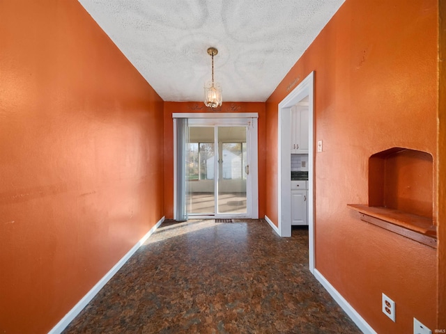 doorway to outside featuring a chandelier and a textured ceiling