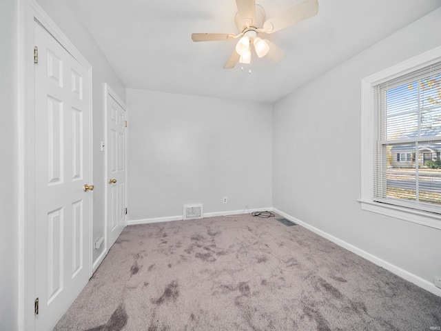 carpeted spare room with ceiling fan