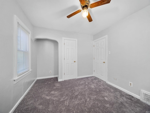 interior space featuring dark colored carpet and ceiling fan