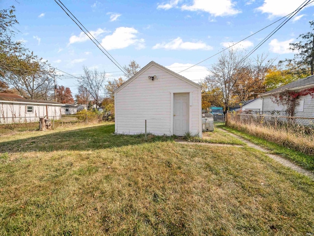 back of house featuring a storage unit and a lawn