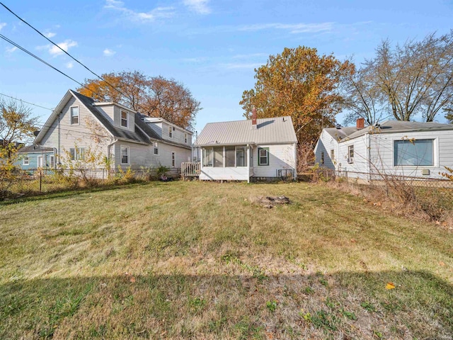 back of house with a yard and a sunroom