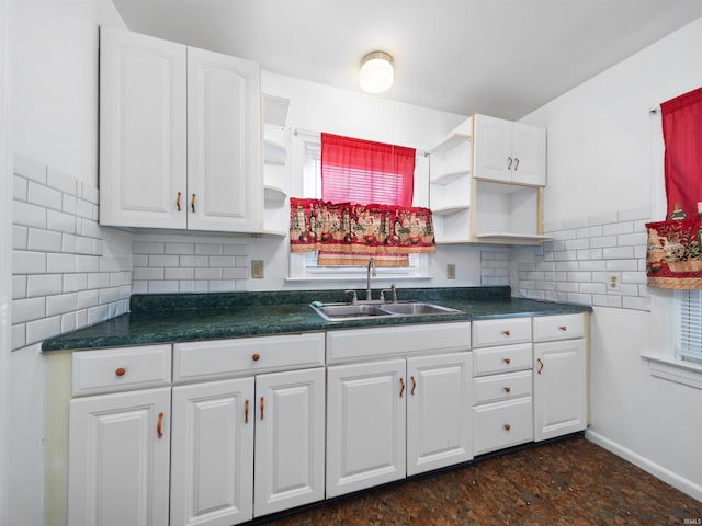 kitchen with decorative backsplash, sink, and white cabinets