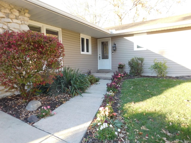 property entrance with a lawn