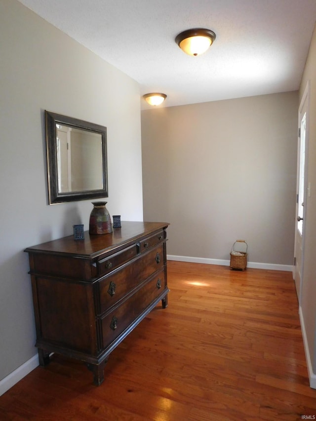 corridor with dark hardwood / wood-style flooring