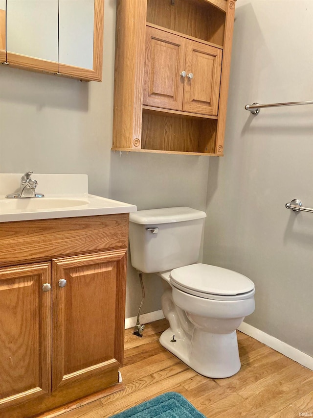 bathroom featuring vanity, toilet, and hardwood / wood-style floors