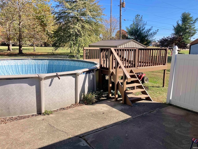 view of pool featuring a wooden deck and a lawn