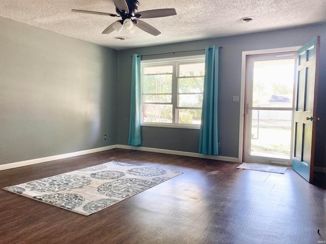 spare room with ceiling fan, a textured ceiling, and dark hardwood / wood-style floors