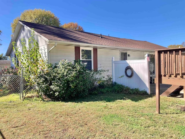 view of home's exterior with a wooden deck and a yard