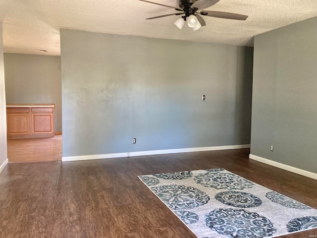 spare room featuring ceiling fan, a textured ceiling, and dark hardwood / wood-style flooring