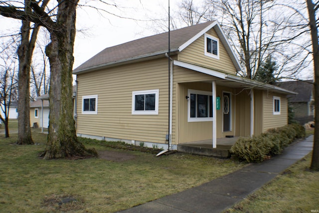 view of property exterior featuring a porch and a yard