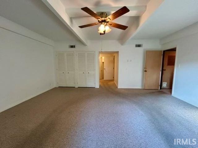 unfurnished bedroom with beam ceiling, carpet, and ceiling fan