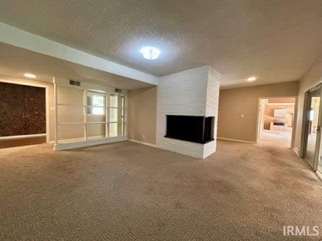 unfurnished living room with carpet, a textured ceiling, and a fireplace