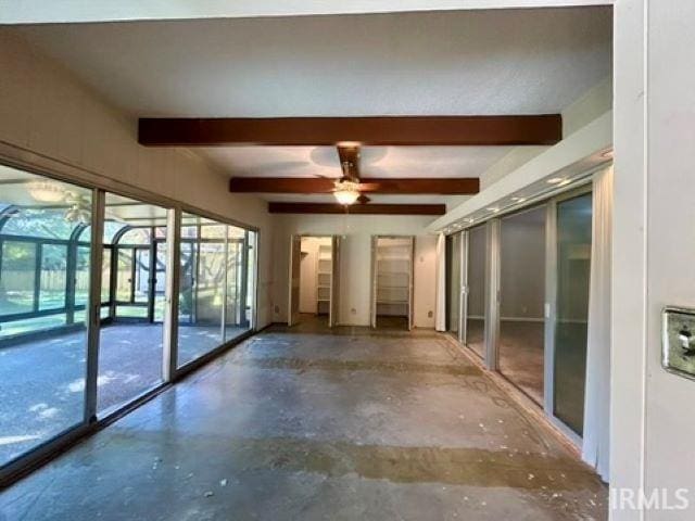 interior space with beamed ceiling, concrete floors, and ceiling fan