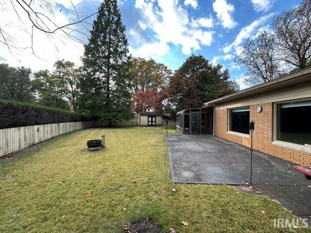 view of yard featuring a shed and a patio area