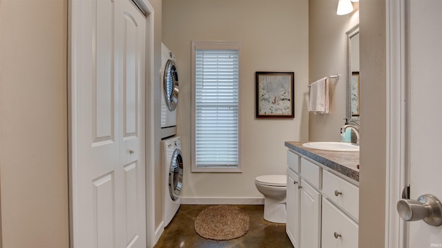 bathroom with vanity, stacked washer and clothes dryer, toilet, and tile patterned floors