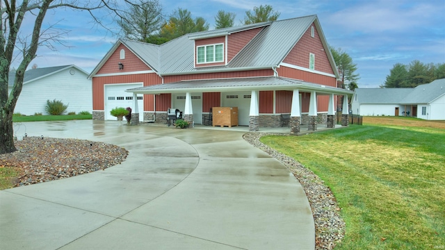 view of front facade with a porch, concrete driveway, stone siding, and a front yard