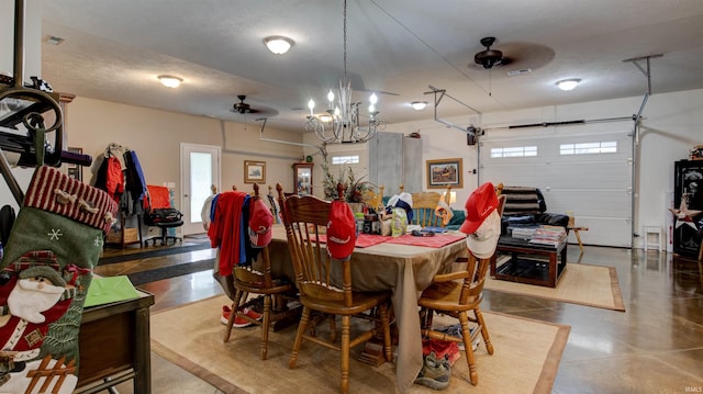 dining space with concrete floors, a textured ceiling, and ceiling fan with notable chandelier