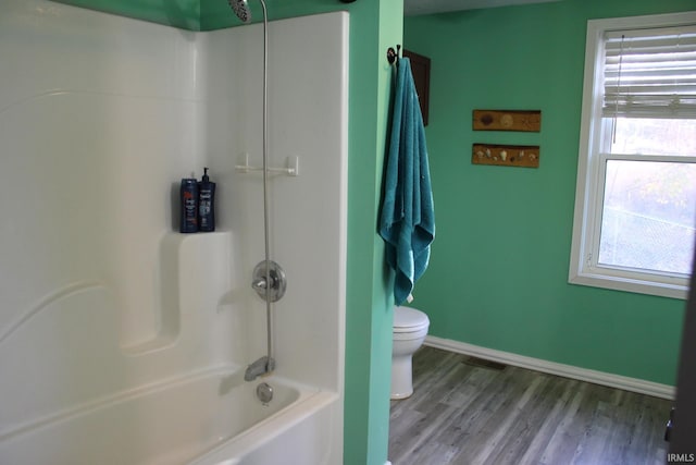 bathroom with shower / tub combination, hardwood / wood-style flooring, and toilet