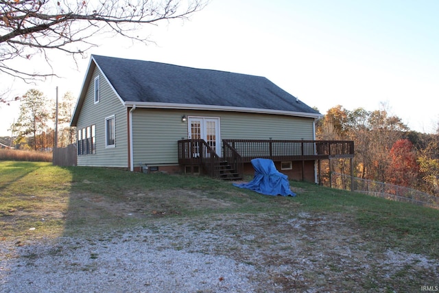 rear view of house featuring a wooden deck, french doors, and a yard