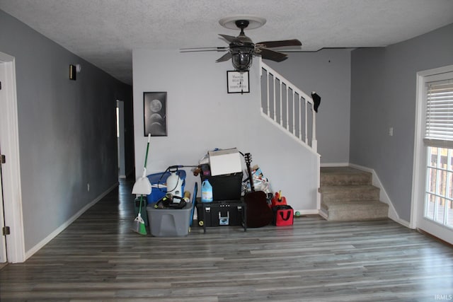 living room featuring a textured ceiling, wood-type flooring, and ceiling fan